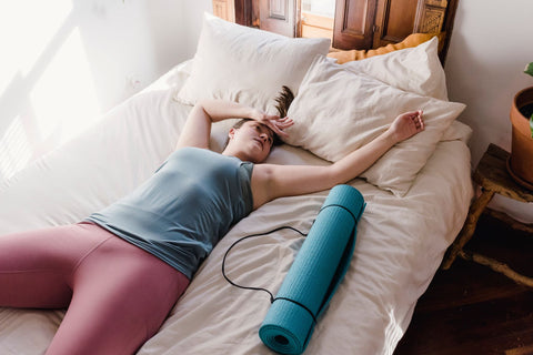 Exercise makes your temperature go up at night, woman lying on bed exhauseted from exercise