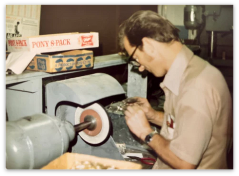 Stanley Zaleski, one of Randolph Engineering's founders, examining frames in the machine shop. 