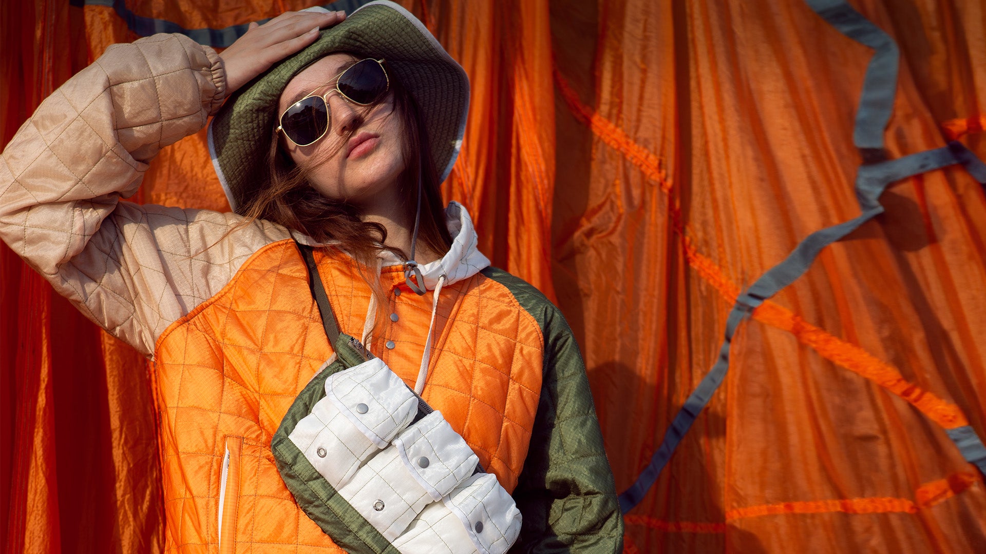 A female modeling the collaborations, Satin Gold Aviators, and the apparel and accessories of the collaboration