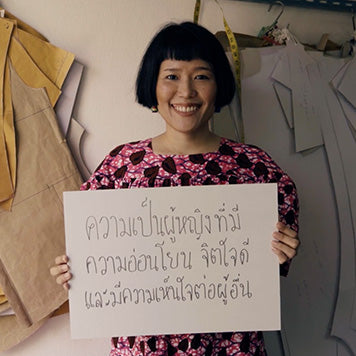 Young woman holding a sign explaining what femininity means to her