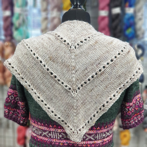 Small grey triangular shawl  just covering the shoulders of the mannequin