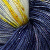 Close up view of some blue yarn twisted into a skein, with a white patch with some yellow and subtle sparkles
