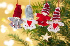 Picture of 4 knitted christmas characters hanging from a christmas tree