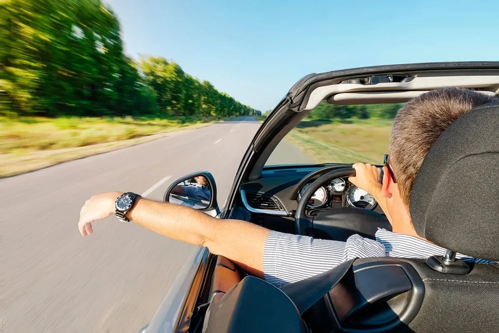 Calm happy successful man sitting on his car