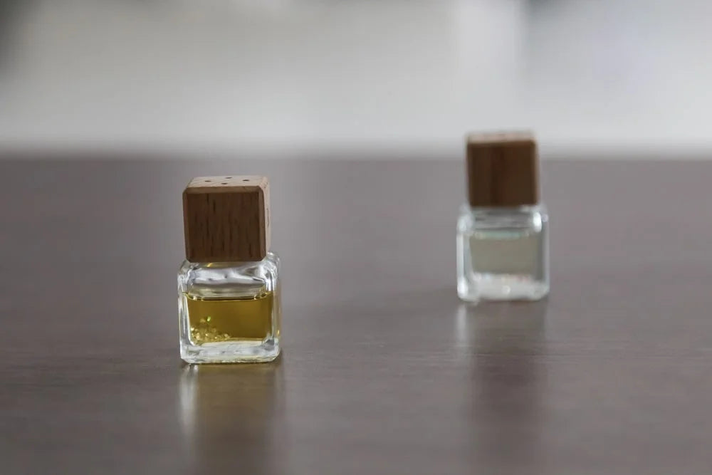 Two small perfume bottles on table