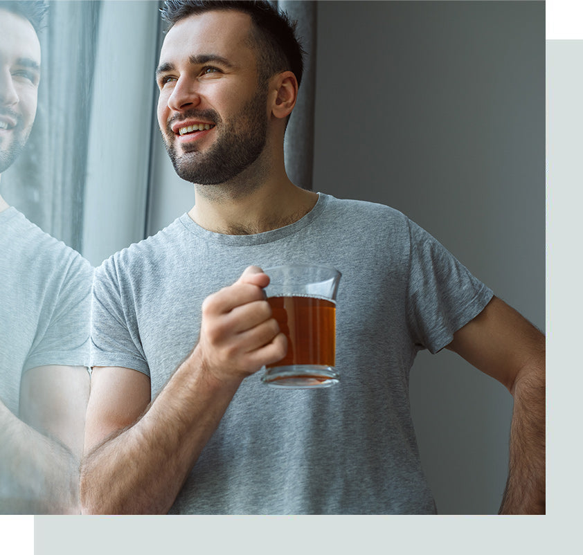 Man enjoying hot cup of tea looking out window