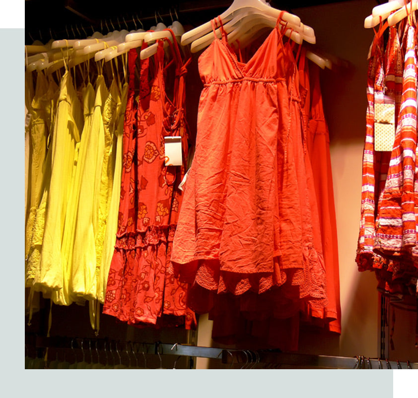 Summer dresses hanging on a rack at a clothing store.