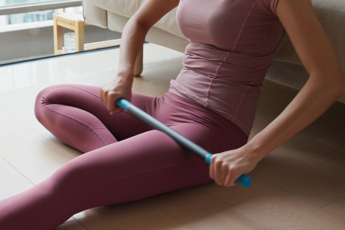 Woman Using Muscle Roller Stick on Her Thigh