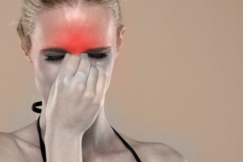 woman holding her nose in pain