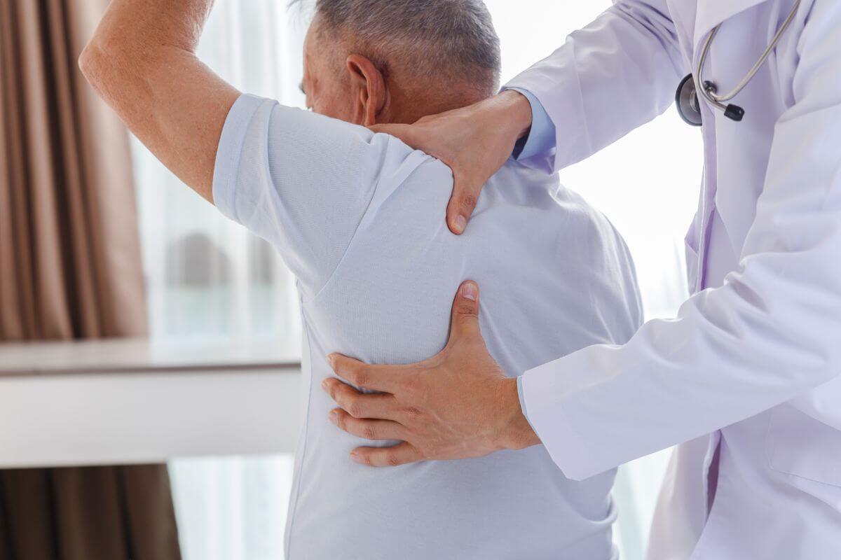 Man Raising Arm While a Chiropractor Holding His Shoulder