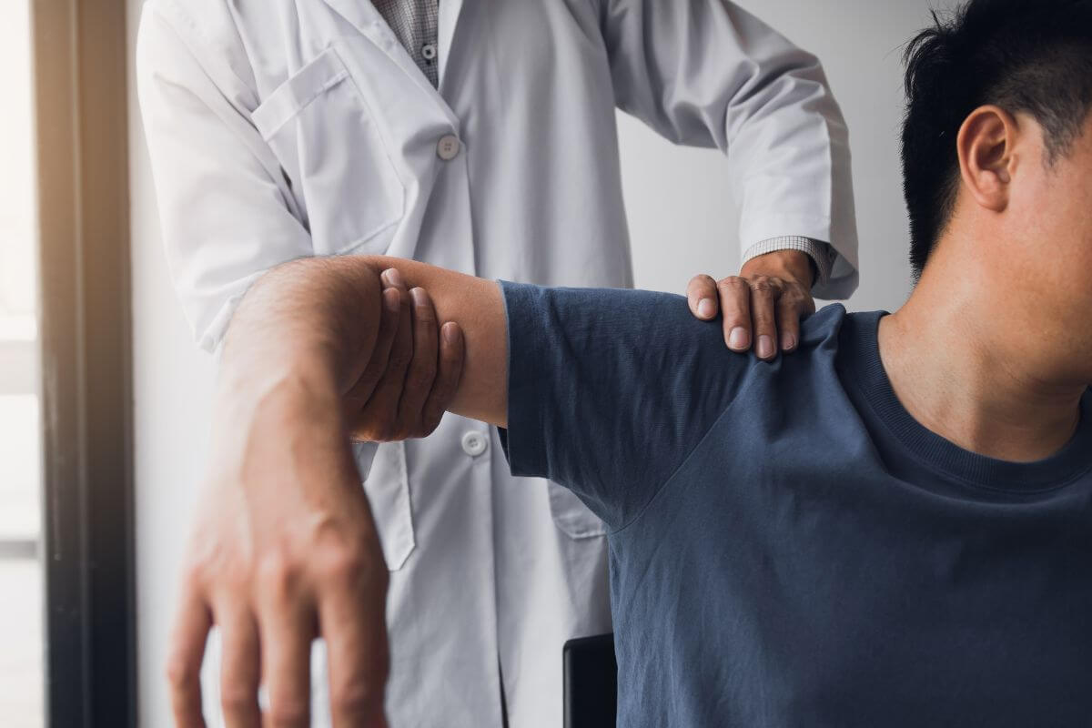 Chiropractor Raising Man's Arm