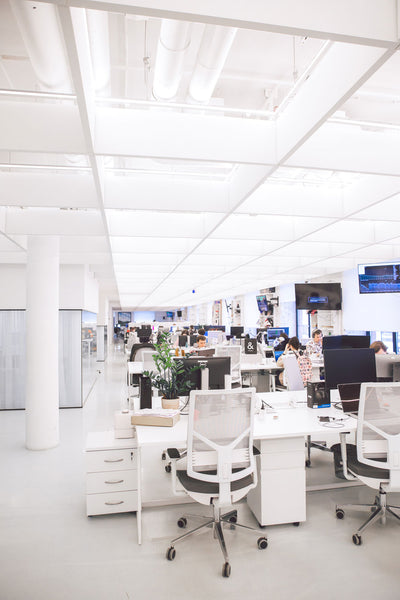 white office furniture including white desks and white mesh chairs