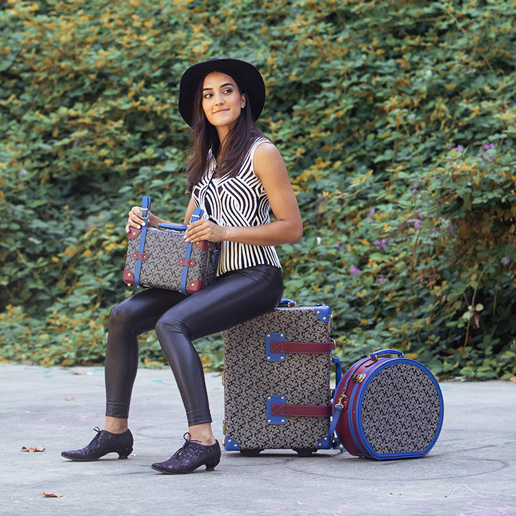 Woman sitting with Fluevog x SteamLine Luggage collaboration collection