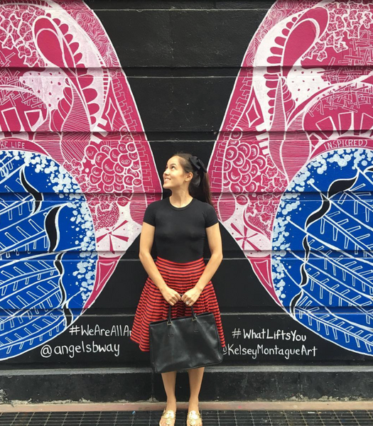 Juliet poses with Kelsey Montague's interactive Angels in America mural outside the Neil Simon Theatre on 52nd Street. May its doors open soon!