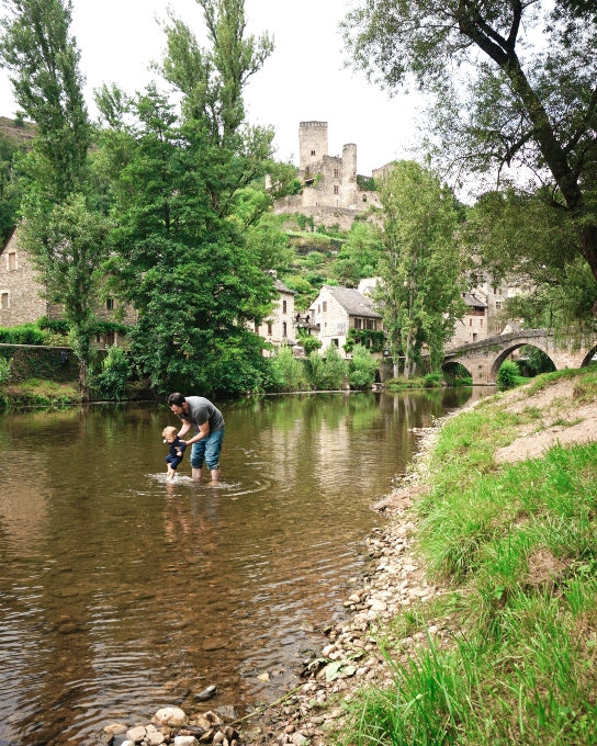 Whitney's husband Adam rinses West's feet in the Aveyron river in the medieval village of Belcastel (Aveyron, France), Whitney’s home-away-from-home for the last ten years.