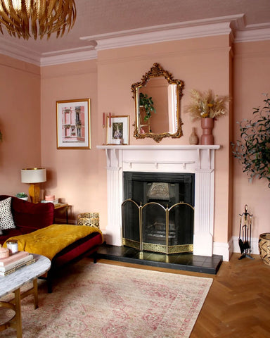 Salon avec cheminée et murs peints en rose