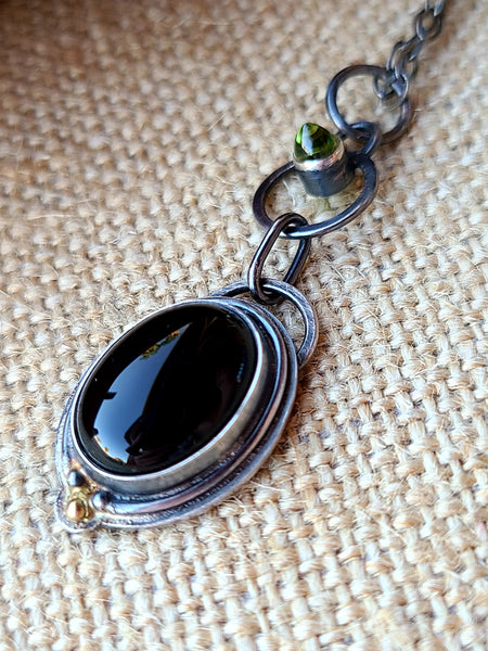 Halo necklace with onyx and peridot in silver and 14k gold
