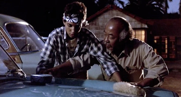 Mr. Miyagi teaches Daniel how to wax on, wax off in The Karate Kid