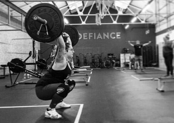 Woman Holding An Overhead Squat In Crossfit Workout