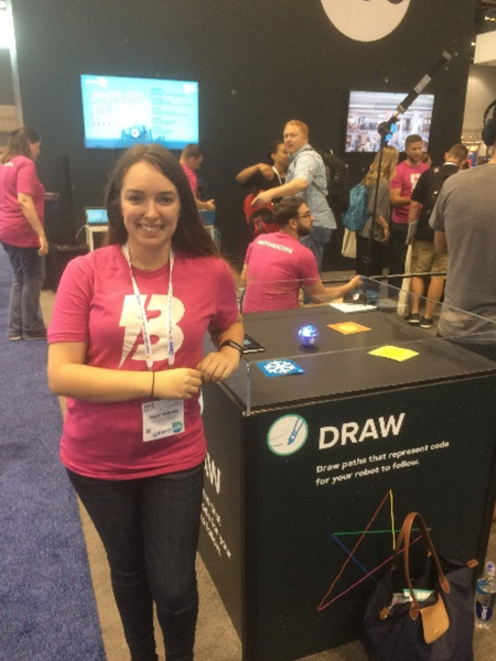 Woman standing by Sphero display with pink BOLT shirt on.
