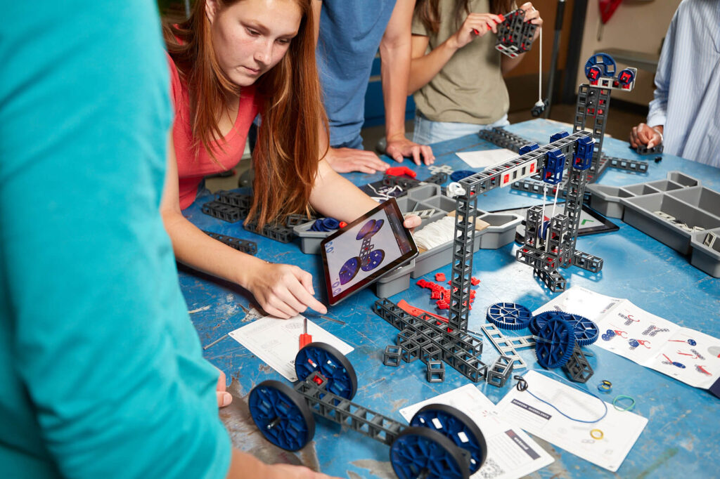 A female engineering student works on her Blueprint Build design in a makerspace style classroom.