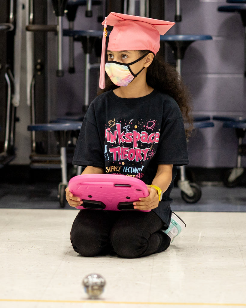 A girl codes a Sphero BOLT as part of the Pink Space Theory STEM program for girls.