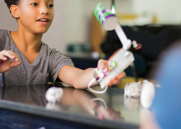 A girl with her littleBits ball throwing invention.