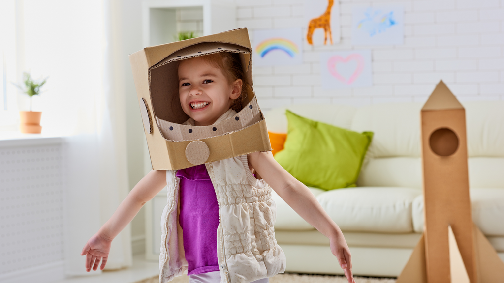 A girl wears her homemade astronaut costume made out of cardboard.