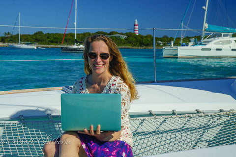 Lucy sitting on bow with computer, Hope Town Bahamas