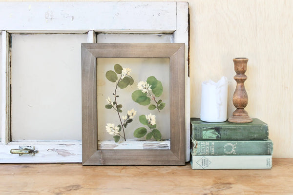 Framed Print on a bookshelf next to books. Made by Frame and Flora