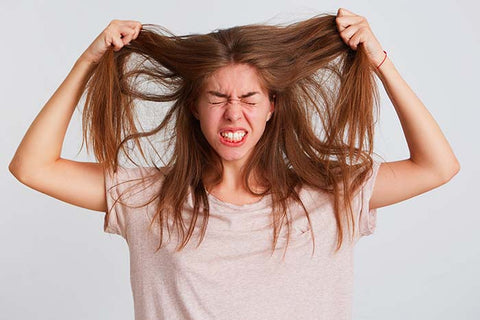 Ragazza a cui non piacciono i propri capelli grassi, quale shampoo usare