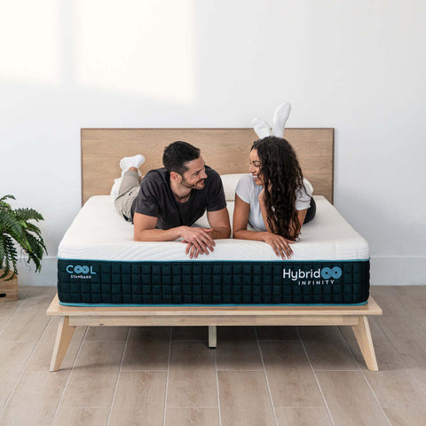 Couple laying on their stomachs on a hybrid infinity mattress