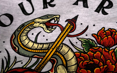 a t-shirt print of a snake with its tongue wrapped around a pencil