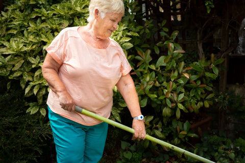 Elderly woman independently managing her garden