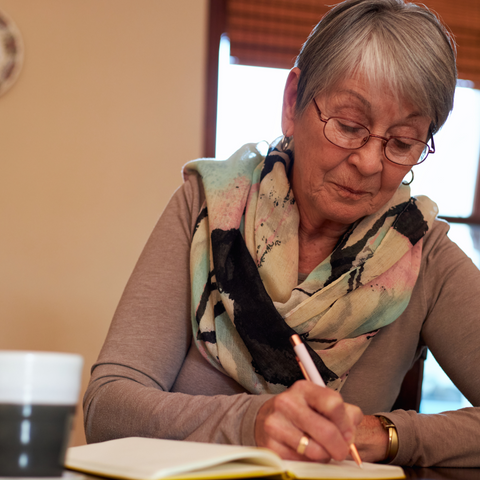Elderly woman doing mindful journalling