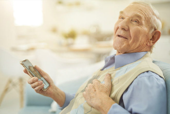 Elderly man struggling to use mobile phone