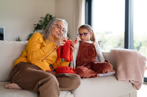 Elderly woman knitting with granddaughter
