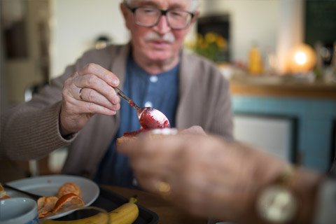 Elderly man having breakfast