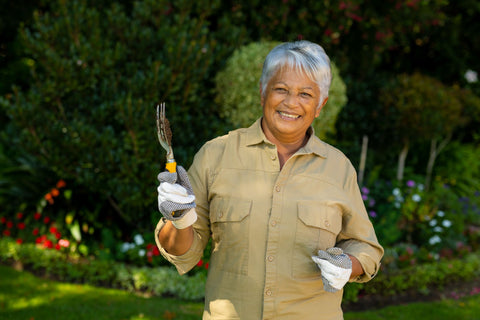 Elderly woman wearing gloves while gardening