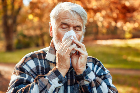 Elderly man outdoors with signs of seasonal allergy