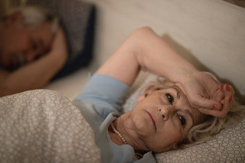 Elderly woman lying awake in bed