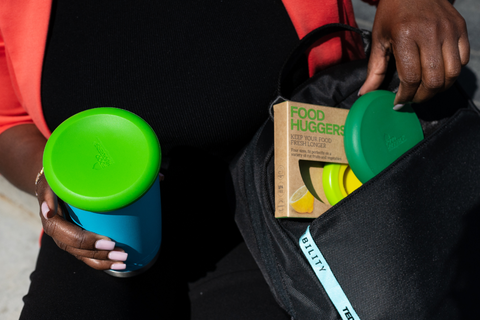 Hands of a woman with a black bag, which contains several Food Huggers, the solution to achieve zero food waste.