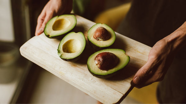 Avocados halved on a tray