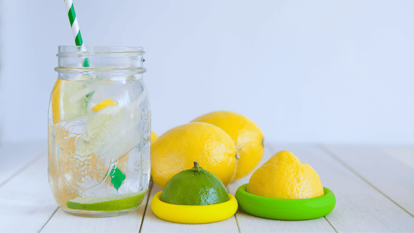 Cut of water on counter with lemons and one lime half in Food Huggers