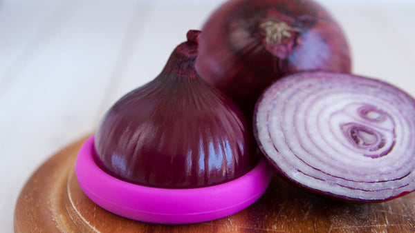 Half an onion inside a Food Hugger Next to another half onion