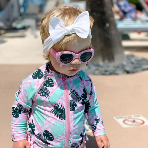 Baby girl in a SwimZip rash guards and sunglasses—Best rash guards