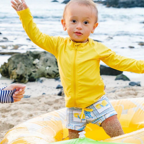 Boy in a SwimZip lemon euro swim shorties plays at the beach—Best swimsuits.