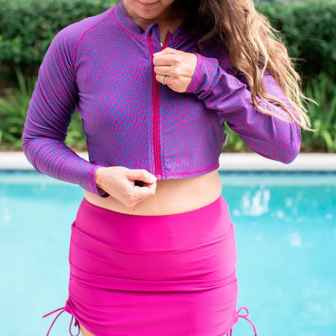 Woman in a SwimZip cropped rash guard with a swim skirt by the pool—Best swimsuits