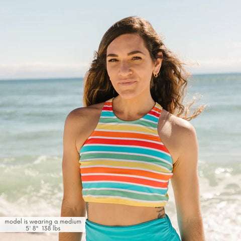 Woman in a SwimZip Rainbow halter bikini top and blue high-waisted bottom at the beach—Best bathing suits for women.