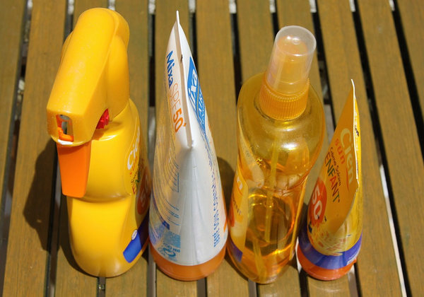 different sunscreens placed on top of a wooden bench